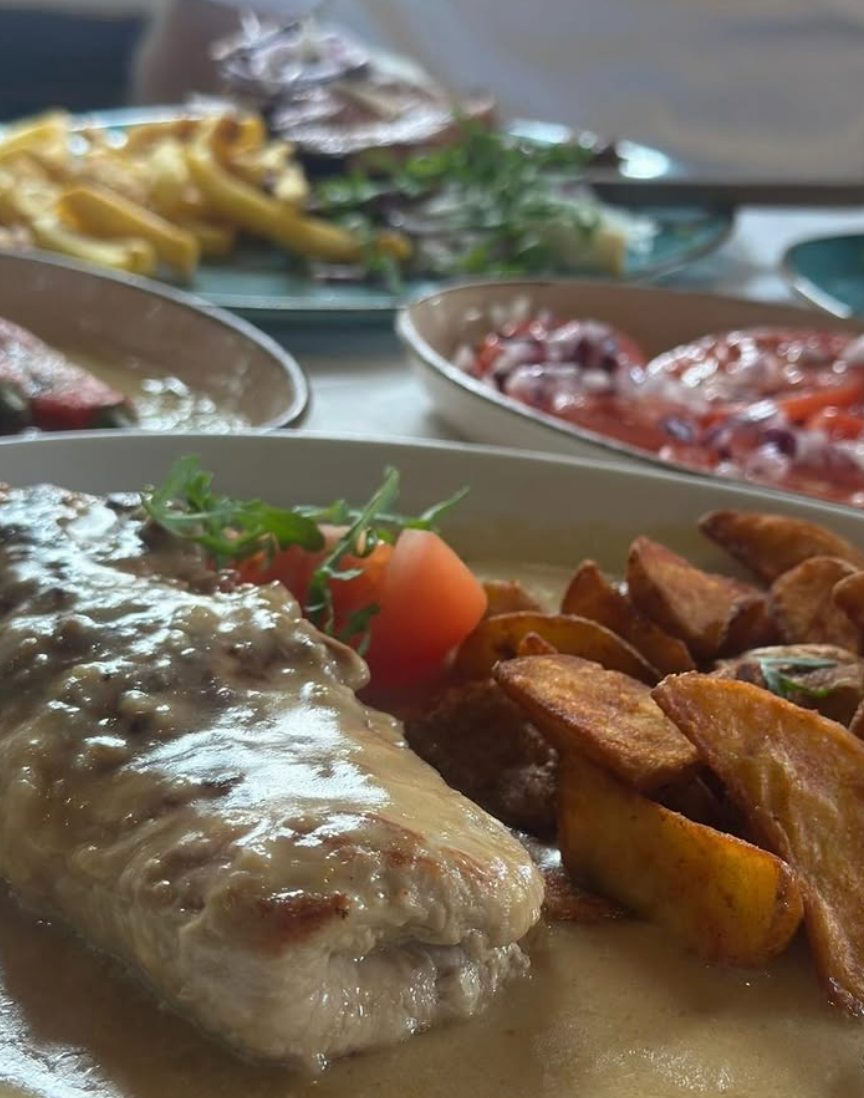 Schnitzel mit Kartoffelspalten in Rahmsauce