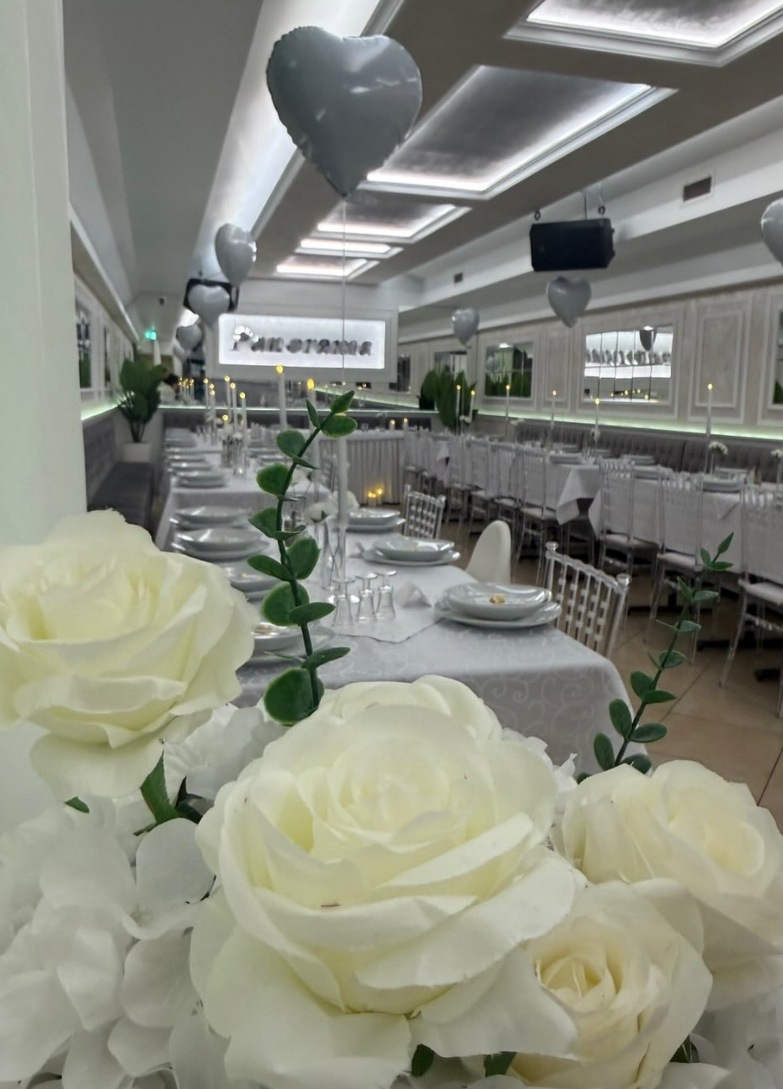 Festlich dekorierter Festsaal mit weißen Rosen